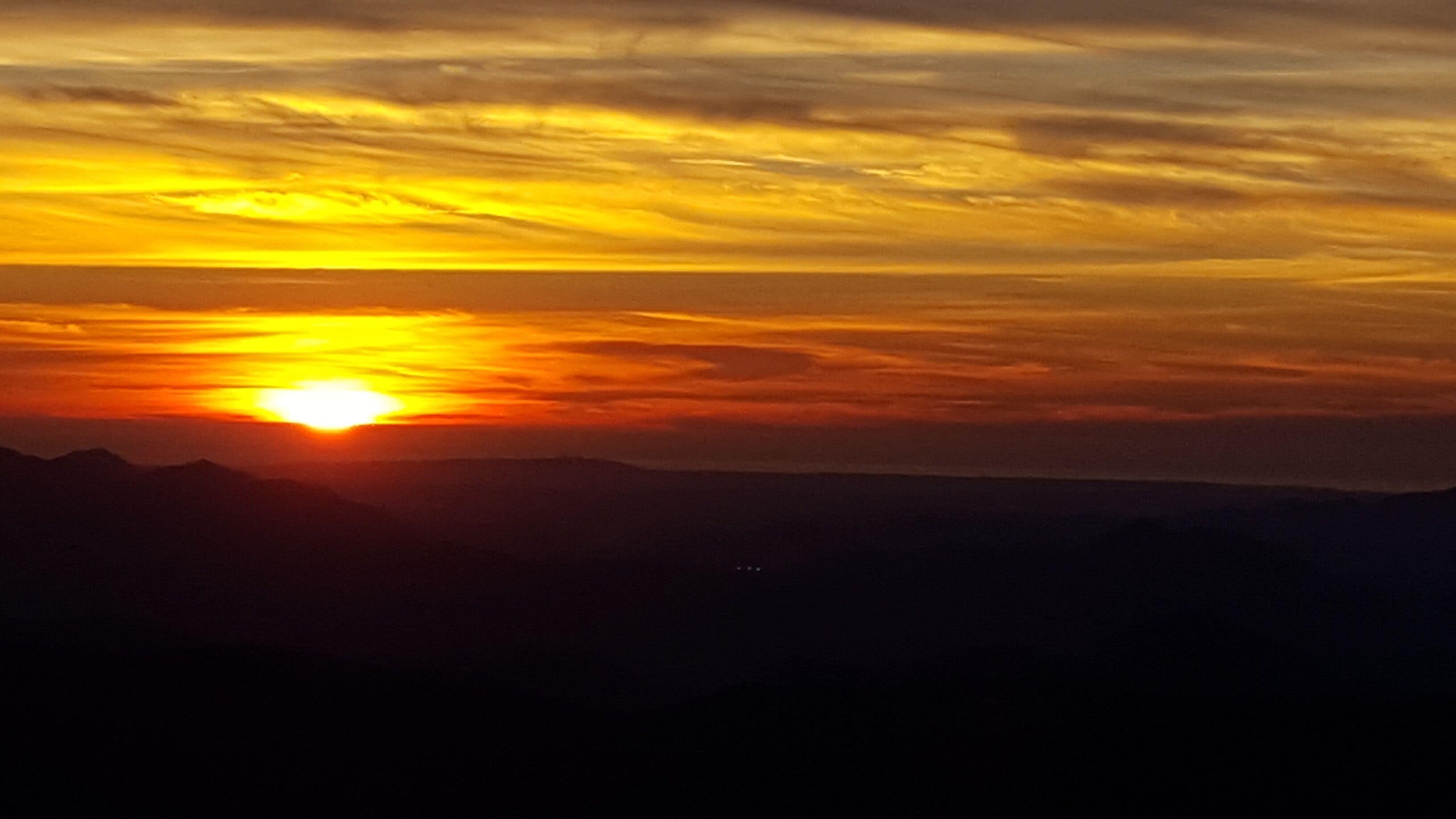 A sunset over a mountainous landscape.