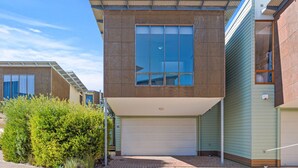 A modern two-story house with a garage, large windows, and a covered entryway.