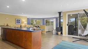 Relax in this inviting space with a central island, large window, and sliding glass door leading to an outdoor area.