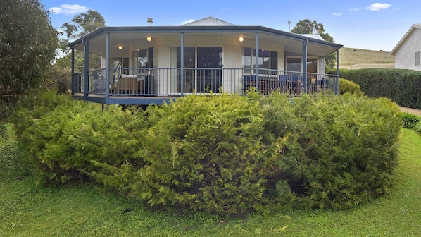 A two-story house with a covered porch and a lawn.