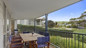 Enjoy the serene view from this balcony with a table and chairs.