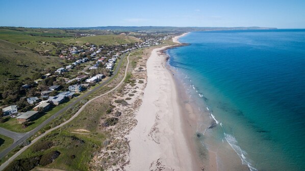 Stunning coastal homes line the beach, offering serene ocean views.