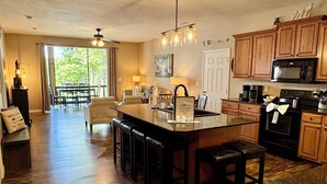 A spacious kitchen with wooden cabinets, a central island, and a dining area with a view to the outdoors. - 3 BR, 3 Bth, Vickery Resort Lower level with walkout to the lake. (Hollister)