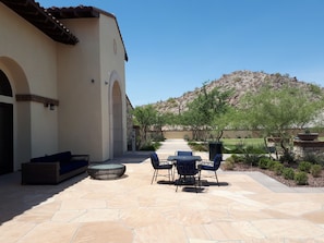 Relax on the patio with a sofa, chairs, and fire pit, surrounded by a scenic mountain view.