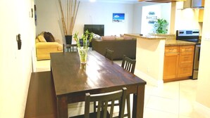 A compact kitchen with wooden cabinets, a built-in microwave, and a refrigerator.