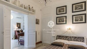 Una camera da letto con un letto, un lampadario, quadri incorniciati e un tappeto decorato.