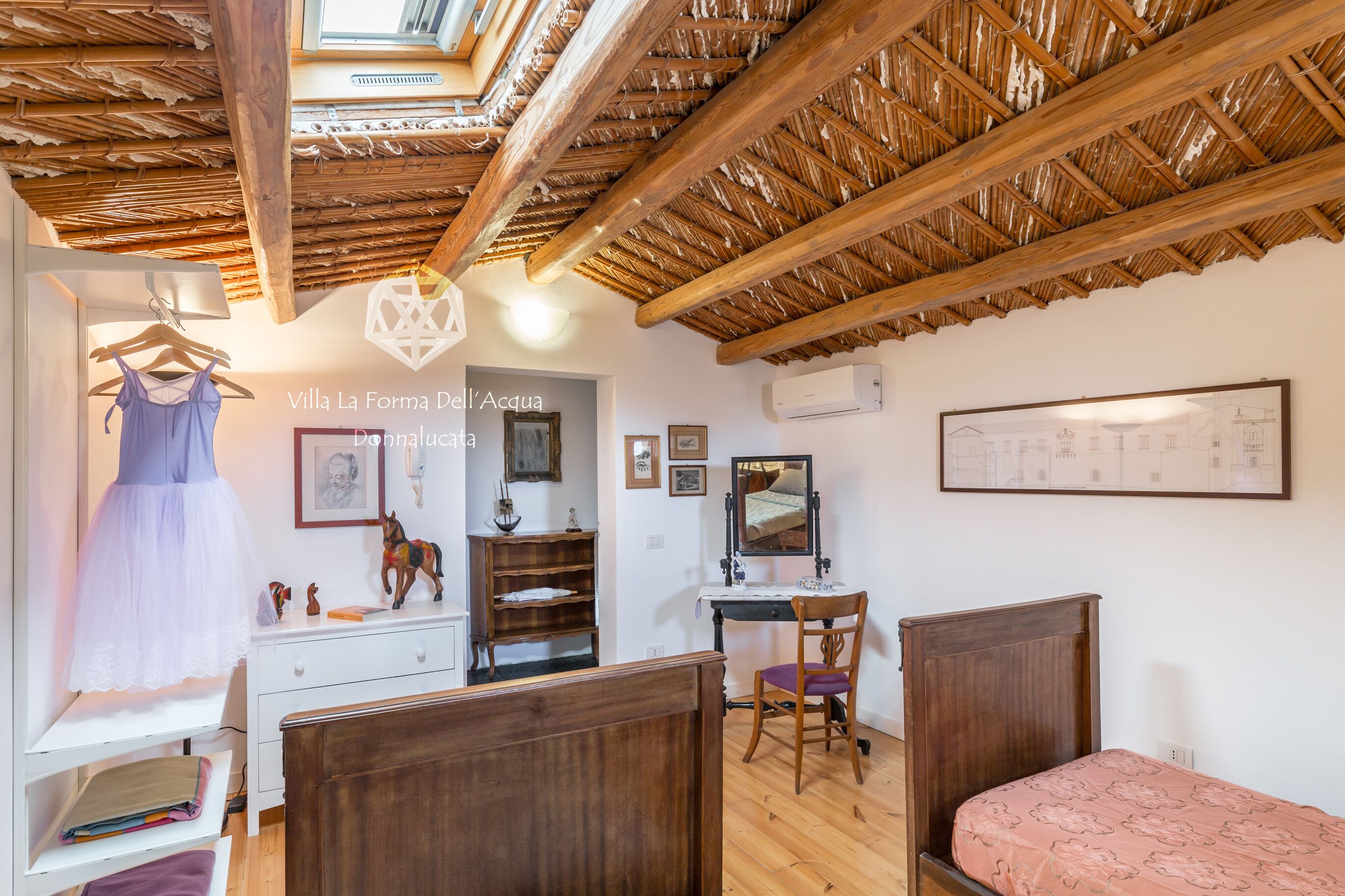 Une chambre avec un plafond en bois, un lit, un bureau et une chaise.