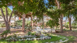Un giardino con uno stagno, rocce e alberi.