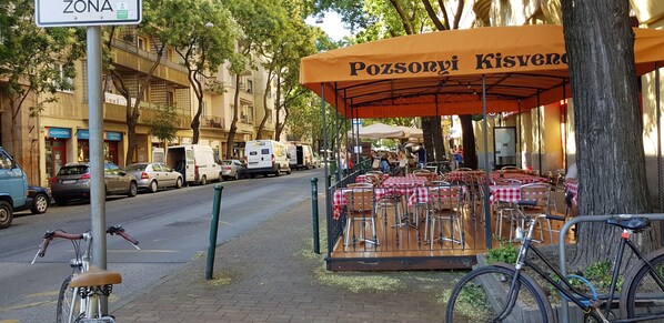 Relax in the shaded outdoor seating area with tables and chairs, perfect for a leisurely meal.