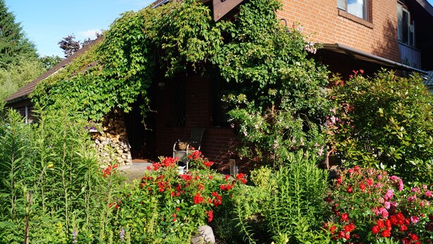 A house with a brick exterior and a garden with various plants and flowers. - Hamburg Rahlstedt / Farmsen, small but very fine (Wandsbek)