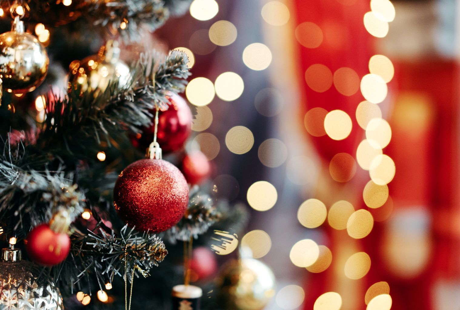 Un gros plan d’un sapin de Noël décoré d’ornements et illuminé de guirlandes lumineuses.