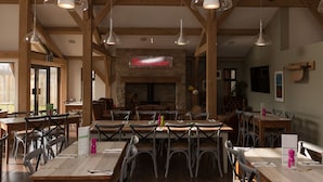 A restaurant with wooden beams, tables, and chairs.
