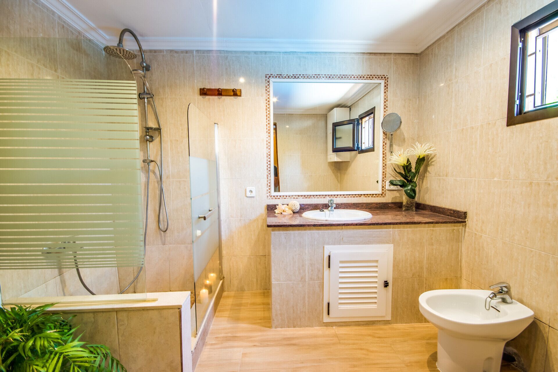 Un baño con ducha, lavamanos y bidé.