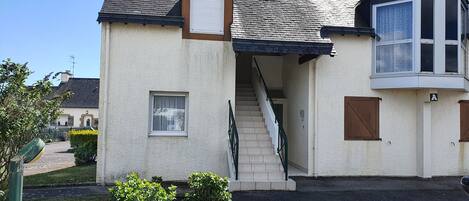 A two-story house with a staircase leading to the upper floor, a small window, and a door marked with the letter 'A'.