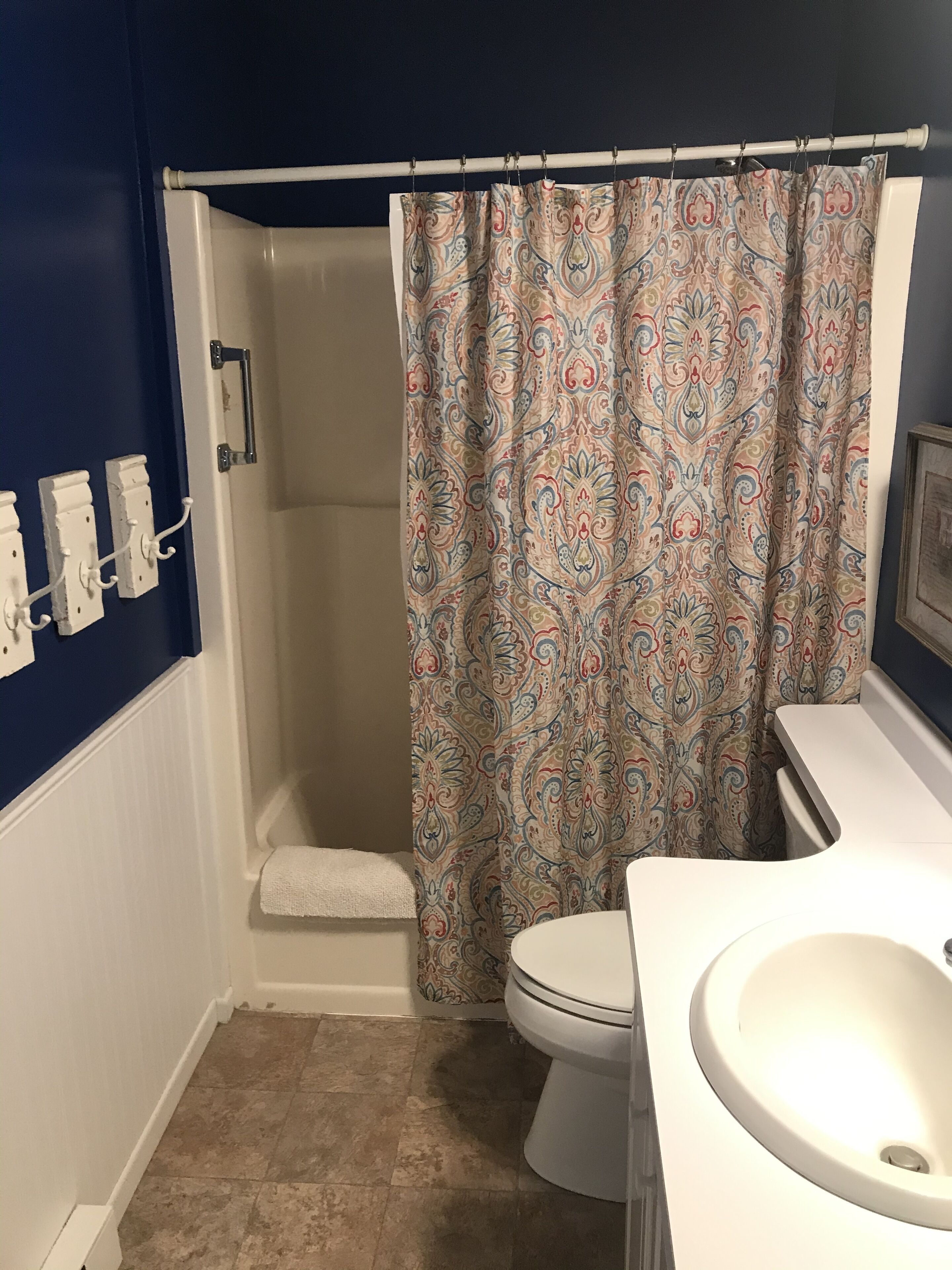 A bathroom with a shower, toilet, and sink.
