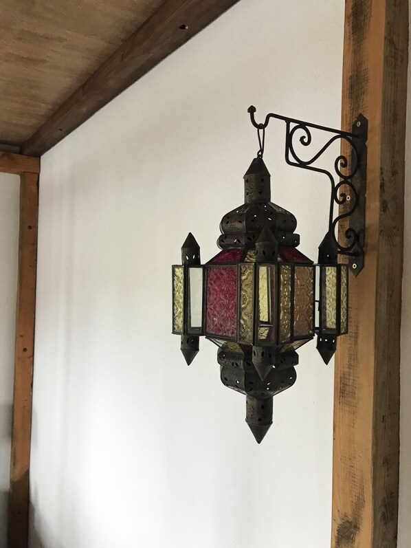A wall-mounted lantern with intricate metalwork and patterned glass panels.