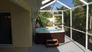 A hot tub on a balcony with a view of palm trees and a clear sky. - Charmer in the Heart of Cape Coral (Cape Coral)