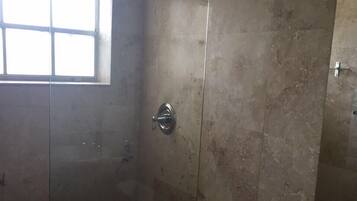 Ein Badezimmer mit Glasdusche, Toilette und Waschbecken.