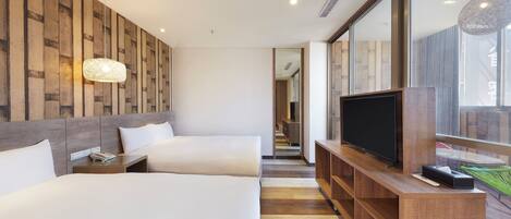 A modern hotel room with two beds, a TV, and a wooden wall panel.