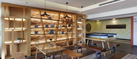 Un interior moderno con estanterías de madera, una mesa de vidrio y bancos.