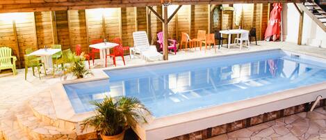 Relax by the pool surrounded by lounge chairs and tables.