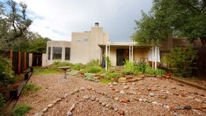 A house with a patio area featuring a stone pathway, a birdbath, and a small garden with various plants and rocks. - Walking trails nearby, Spacious, light filled, well stocked  (Santa Fe)