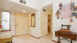 A room with a bed, a sewing machine, and a wall with dolls and a flag. - Walking trails nearby, Spacious, light filled, well stocked  (Santa Fe)