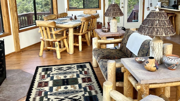 A spacious room with large windows, a wooden dining table, chairs, and a sofa. - Stunning Views Of The Indian Peaks On Mountain Lake (Ward)