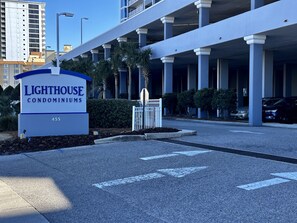 Placa para o Condomínio Lighthouse, com um edifício moderno ao fundo.