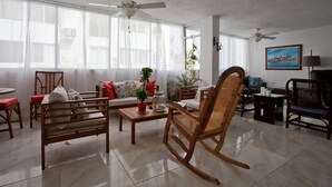 Un salon spacieux avec un canapé, un fauteuil à bascule et une table à manger.