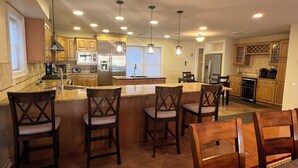 A spacious kitchen with a central island, bar stools, and modern appliances. - SPACIOUS HOUSE WITH POOL OCEANVIEW 3 DECKS 4 MASTER CLOSE TO OCEAN AND BOARDWALK (Wildwood Crest)