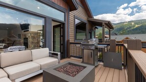 Una terraza con una parrilla, mobiliario exterior y una chimenea.