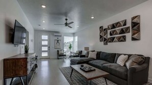 A modern living room with a sofa, coffee table, and a flat-screen TV. - The Lofts #14 | Townhome Pool Resort | Poolside (Saint George)