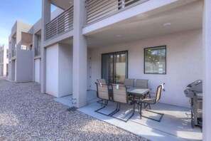 A modern building with a covered outdoor seating area, a grill, and a clear view of the sky. - The Lofts #14 | Townhome Pool Resort | Poolside (Saint George)