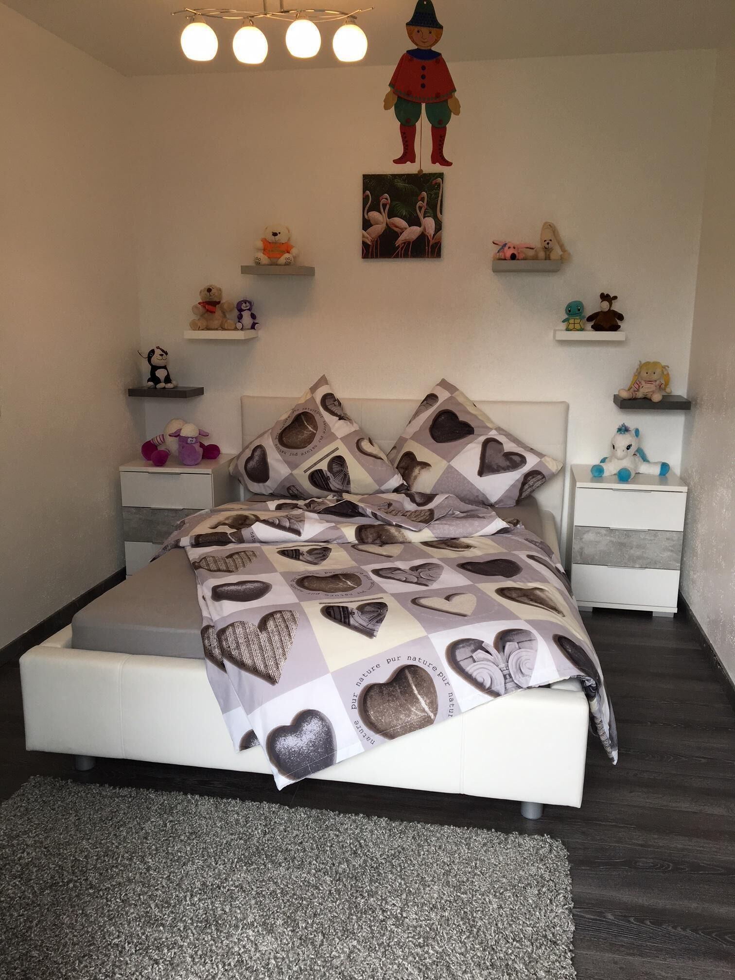Ein ordentlich eingerichtetes Schlafzimmer mit Bett, Nachttischen und Dekoration.