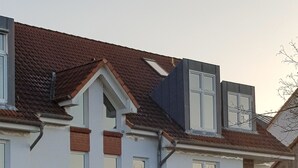 A multi-story residential building with a brick facade, multiple windows, and a visible door. - Wonderful apartment! WLAN Only 400m to the sea and the center (Osteseebad Boltenhagen)