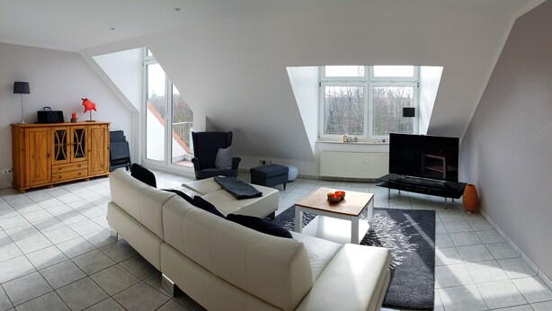 A spacious living room with a high ceiling, a sofa, a coffee table, a TV, and a fireplace. - Wonderful apartment! WLAN Only 400m to the sea and the center (Osteseebad Boltenhagen)