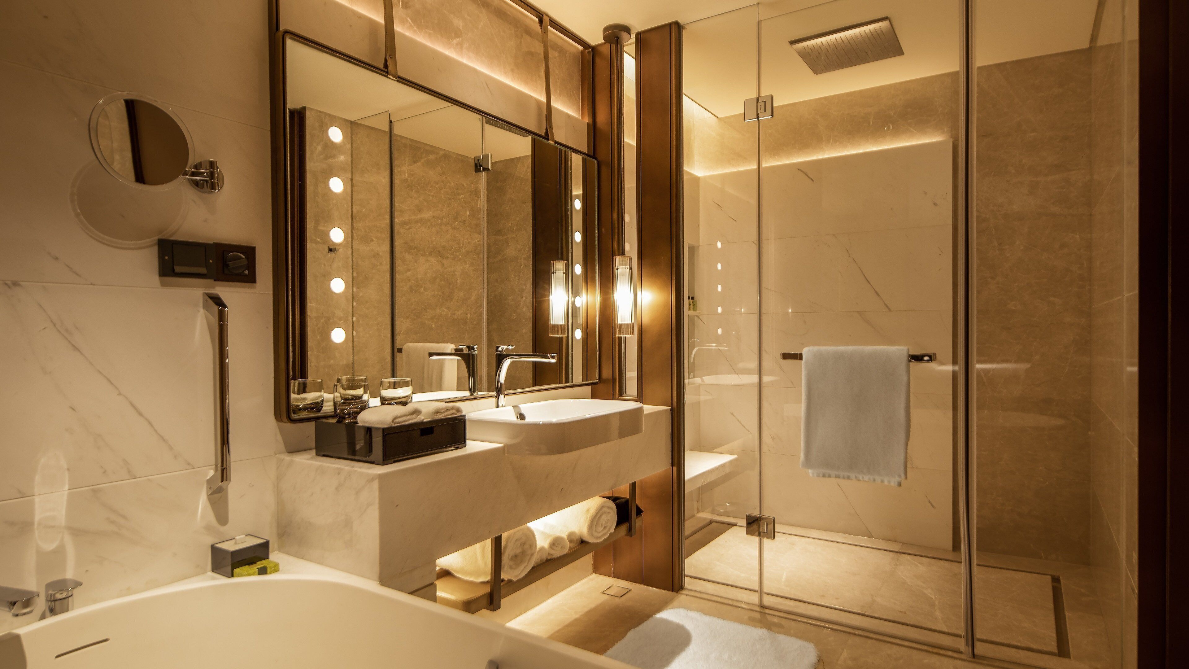 Ein modernes Badezimmer mit großem Spiegel, Waschtisch und begehbarer Dusche.
