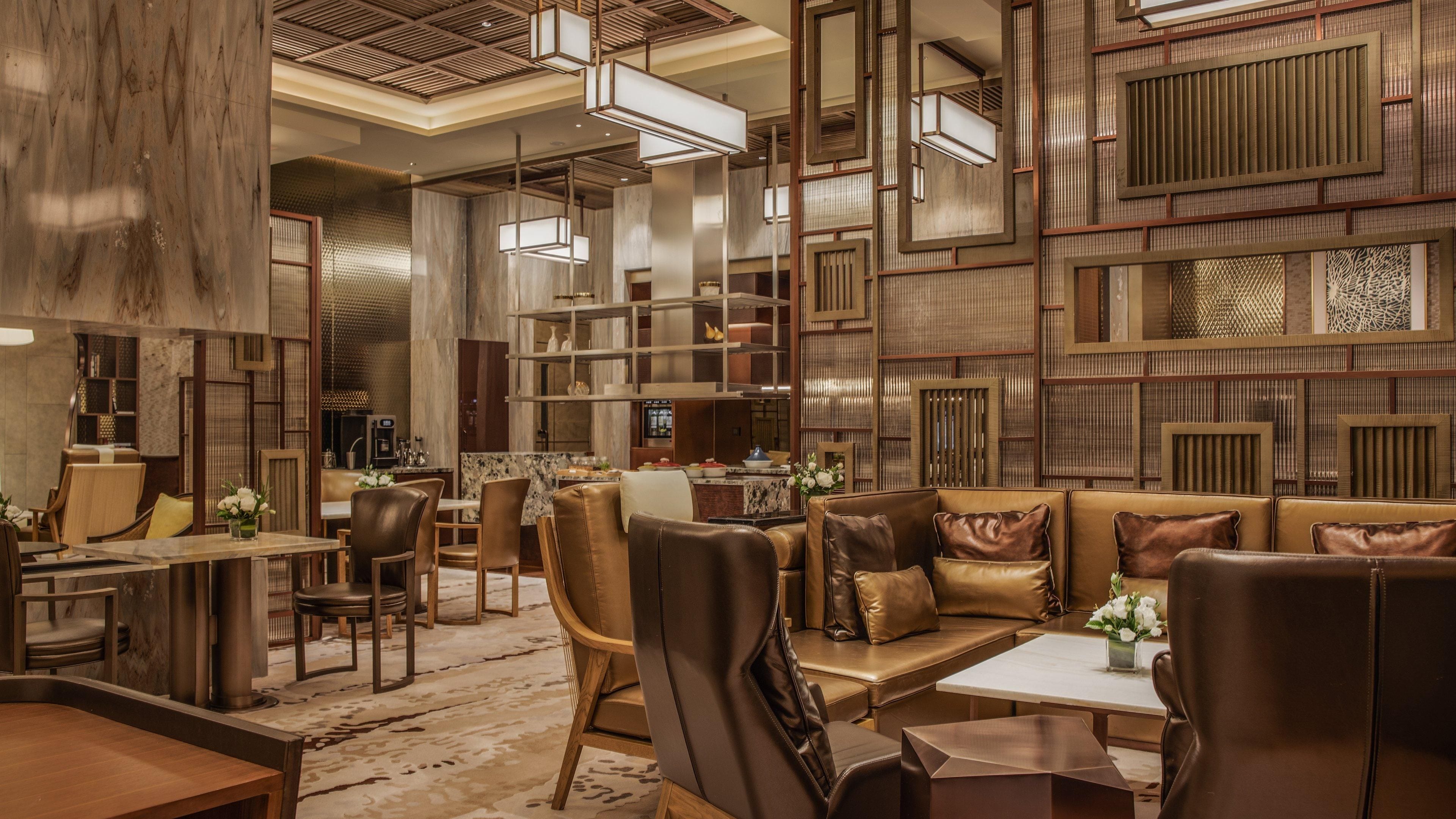 A modern interior with a central seating area, a bar, and a kitchen.