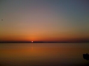 Una masa de agua tranquila con un atardecer.