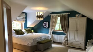 A bedroom with a bed, a nightstand, a wardrobe, and a window with curtains. - The Vandees (Craigavon)