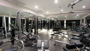 A well-equipped gym with various exercise machines, mirrors, and ample lighting. - Baan Yamu By RESAVA (Pa Klok)