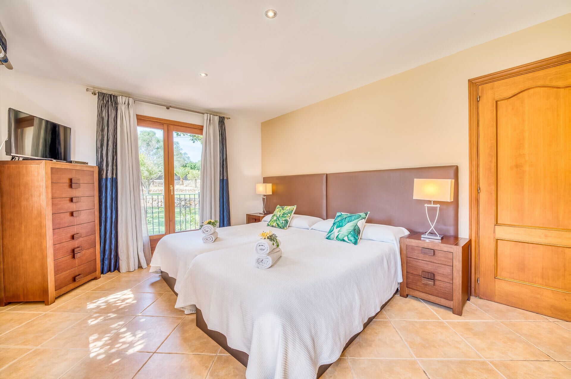 Een hotelkamer met een groot bed, twee nachtkastjes, een kledingkast en een televisie.