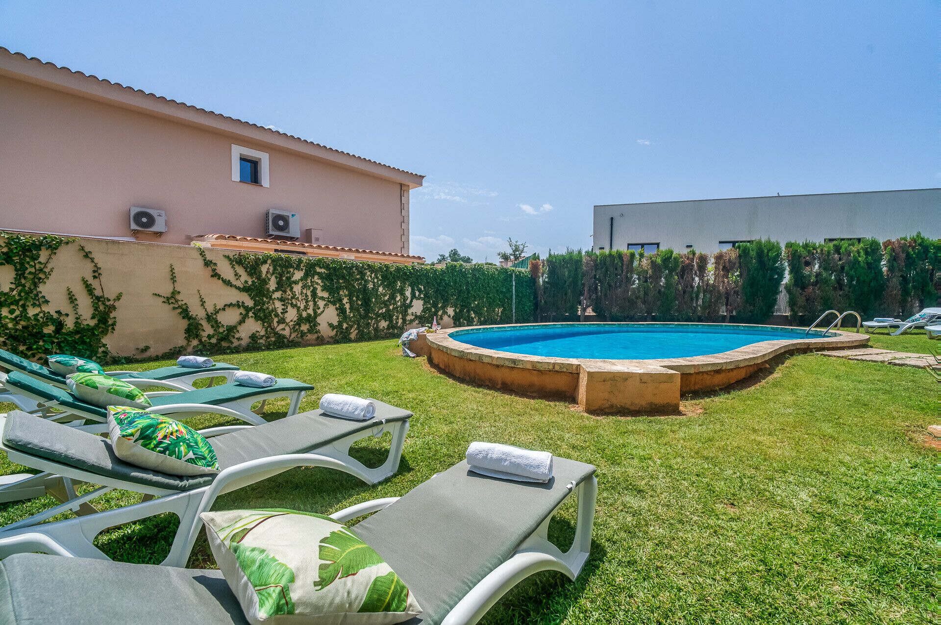 Una piscina con lettini e un edificio sullo sfondo.