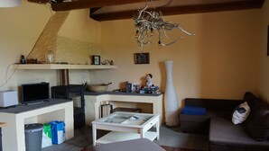 Un salon comprenant une télévision, une cheminée, un canapé et une table à manger.