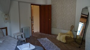 Une chambre à coucher avec un lit, une table de chevet, un radiateur et un miroir.