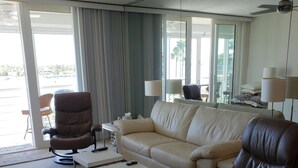 Ein Wohnzimmer mit einer Couch, Sesseln, einem Couchtisch und einem Deckenventilator.