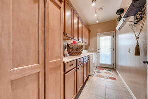Kitchen area with a countertop, cabinetry, and a door leading to another room.