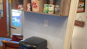 A kitchen with a refrigerator, a coffee maker, and shelves with food items. -  CLEAN, COZY LAKE CABIN COMFORT... (Clifton)