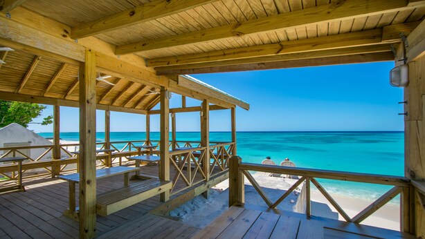 A wooden deck with a view of the ocean. - LUXURY PENTHOUSE!! Courtesy SUV Included, PaddleBoards, Bikes, Chairs & More! (Cockburn Town)